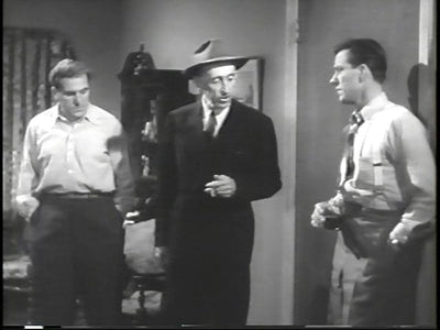 Three men in a room, with the central man wearing a suit and hat, in The Blue Dahlia.